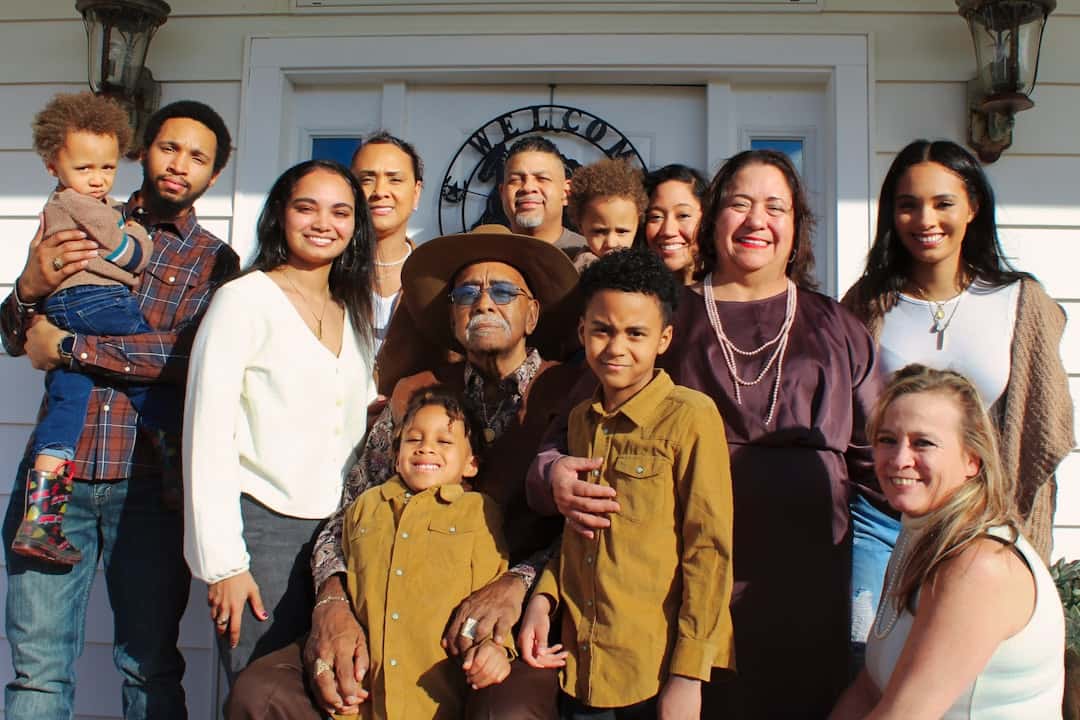 Familia latina de varias generaciones reunida en una cocina con luz cálida